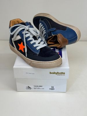 une paire de baskets bleues et orange posée sur une boîte blanche