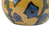 a yellow vase with blue and black designs on it