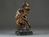 bronze statue of a man and a woman embracing on a marble base