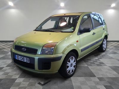une petite voiture verte garée dans une pièce au sol en damier
