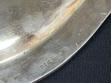 a silver plate on a black table with a black cloth