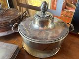 a silver plate with a bird on it on a table
