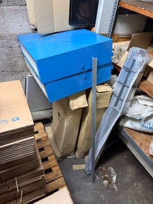 a blue box sitting on top of a pallet in a warehouse