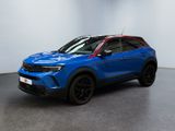 un SUV bleu garé dans une pièce aux murs blancs