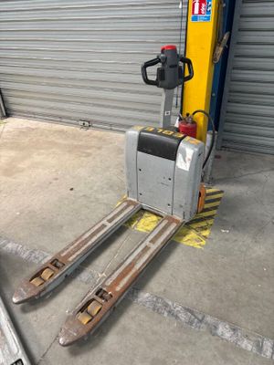 a fork lifter that is parked in front of a garage door