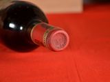 a bottle of wine sitting on a red table cloth