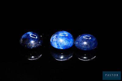 trois billes bleues posées sur une surface noire
