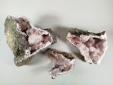 trois morceaux de quartz rose sur une surface blanche