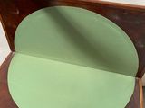 a person holding a piece of wood with a green circle on it