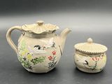 a small tea pot and a small tea pot on a table