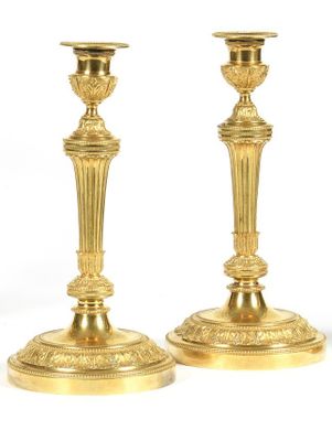 pair of antique brass candlesticks on a white background
