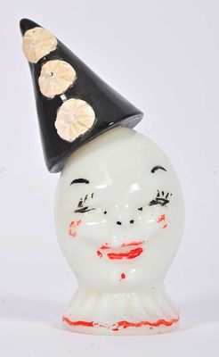 a white vase with a black hat on top of it