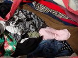 a pile of clothes that is sitting on a bed