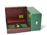 a box with a watch inside of it on a white surface