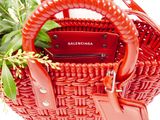 a red basket bag with a tag on it