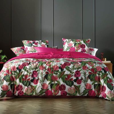 un lit recouvert d'une couette rose et d'oreillers roses