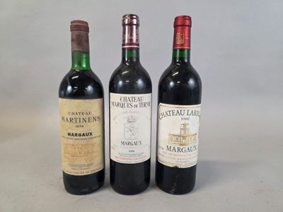 trois bouteilles de vin sont alignées sur une surface blanche