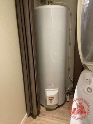 un chauffe-eau dans un coin de la salle de bains