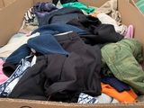 a cardboard box filled with lots of clothes and other items