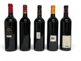 four bottles of wine are lined up in a row on a white surface