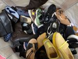 many pairs of shoes that are piled together on a bed