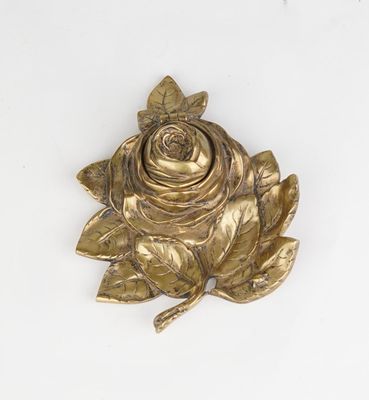 une rose dorée avec des feuilles sur un fond blanc