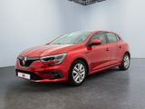 Une voiture rouge est garée dans une pièce au sol noir.