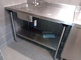 a stainless steel sink in the corner of a bathroom