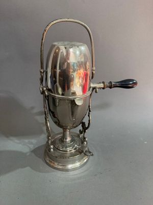 une théière en argent avec une anse sur une table