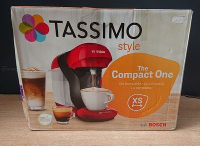 une boîte posée sur une table, sur laquelle se trouve une cafetière