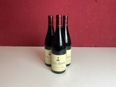 deux bouteilles de vin posées sur une table, avec un mur rouge en arrière-plan