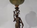 bronze and green vase on a stand with a woman holding a bird