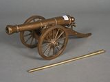 a small wooden cannon with a wooden stick next to it