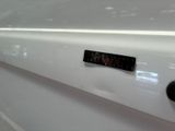 a close up of a clock on the side of a white car