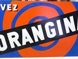 un panneau orange et bleu orné d'une cible, devant un immeuble
