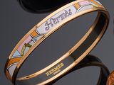 three different colored bang bracelets on top of a black surface