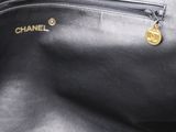 a close up of a black purse with a gold charm on it