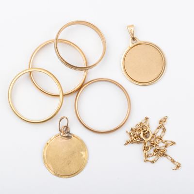 plusieurs types de bagues et de pendentifs en or posés sur un fond blanc