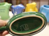 a person holding a green bowl in their hand