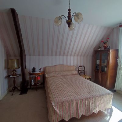 a bed in a room with a chandelier hanging from the ceiling