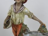 a figurine of a boy with a fish in a bowl