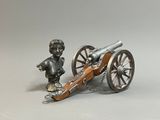 une petite statue représentant un garçon debout à côté d'un canon