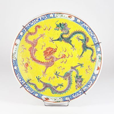 une assiette jaune ornée d'un motif représentant un dragon