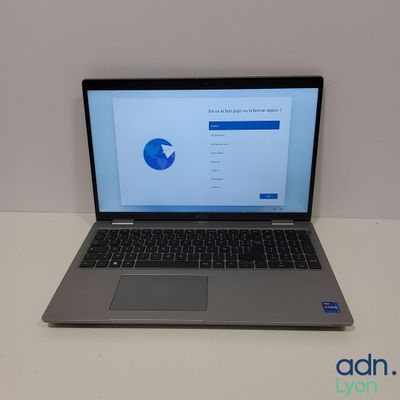 un ordinateur portable ouvert posé sur une table blanche