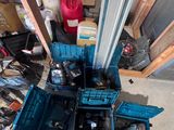 un homme debout à côté d'un tas d'outils dans un garage