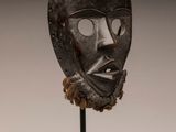 image d'un masque en bois sur un support sur fond blanc