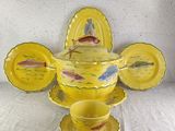 a yellow tea set with a fish design on it