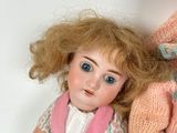 two dolls sitting next to each other on a table