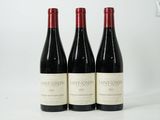 three bottles of wine are lined up on a white surface