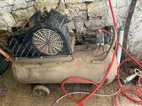 a small air compressor sitting in the corner of a room
